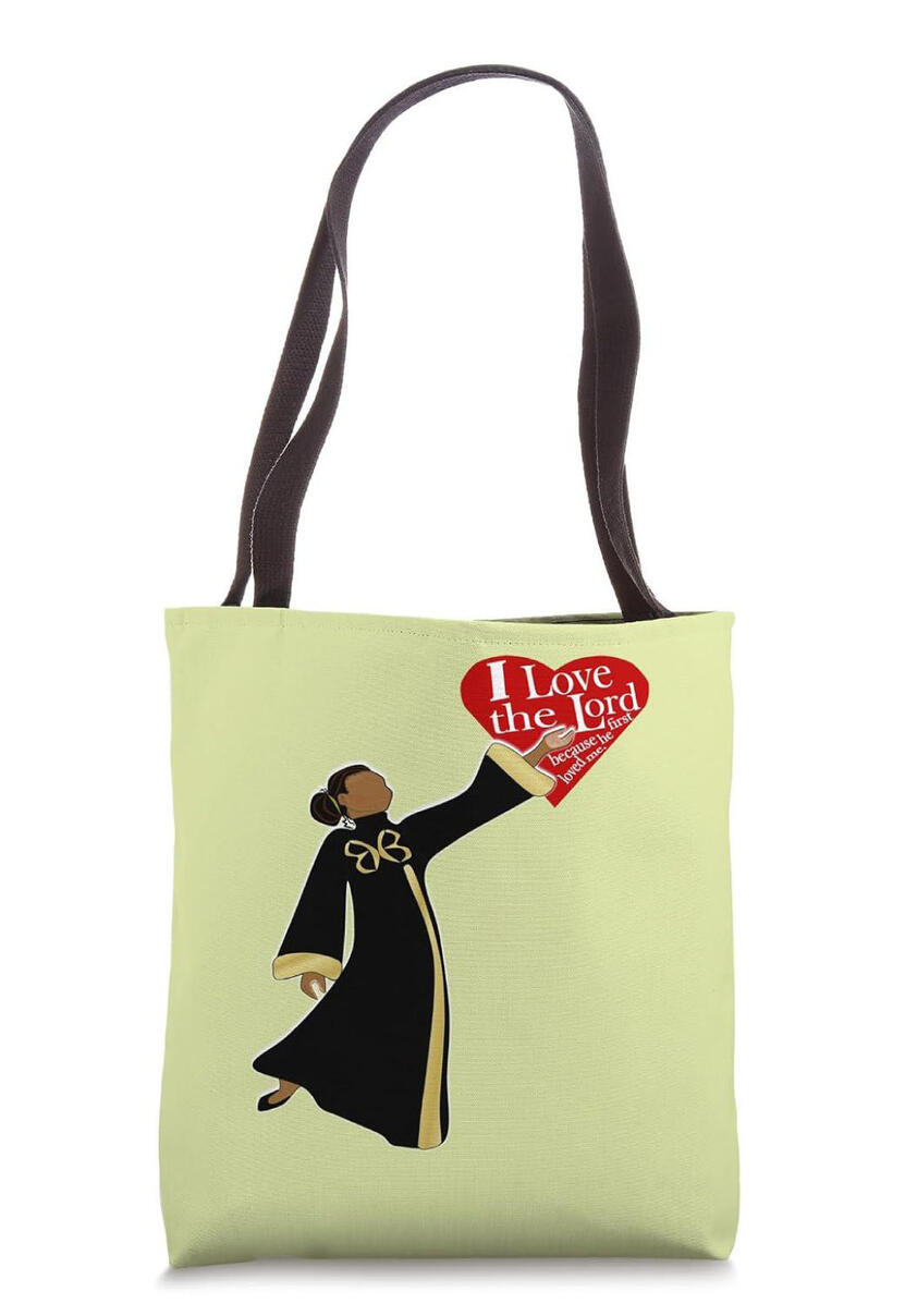 I Love The Lord Because He First Loved Me Christian Tote Bag, Features a woman dressed in liturgical attire with word art in a big heart.